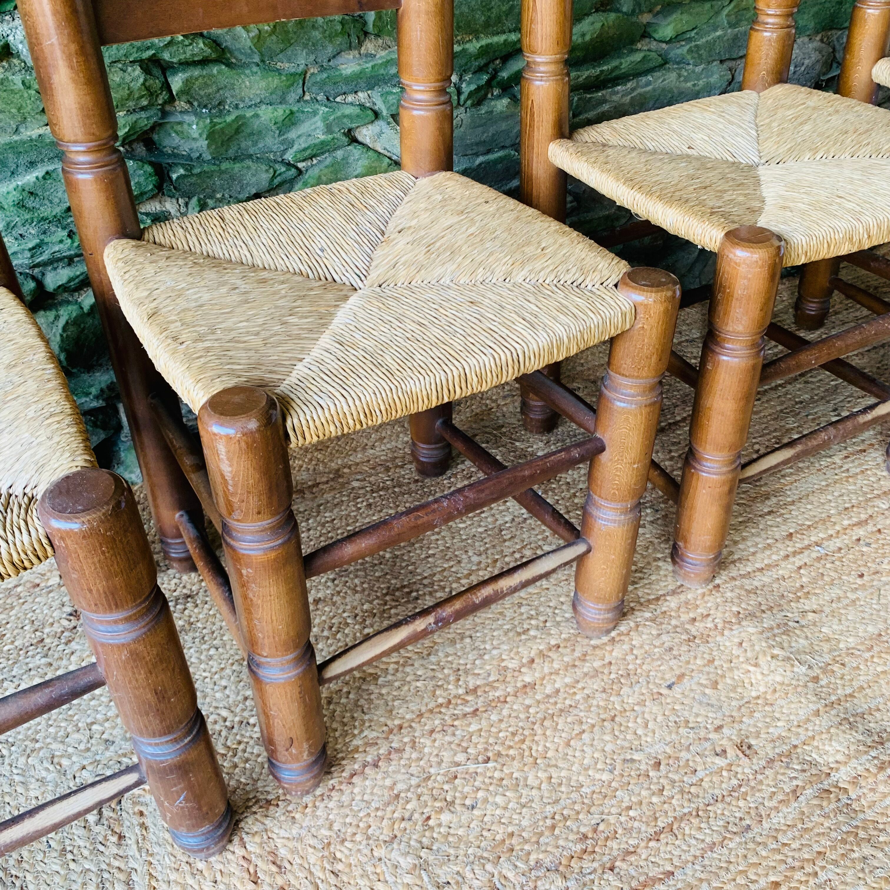 Set of 4 solid wood chairs with straw seats.