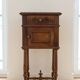 Antique wooden bedside table with a marble top.