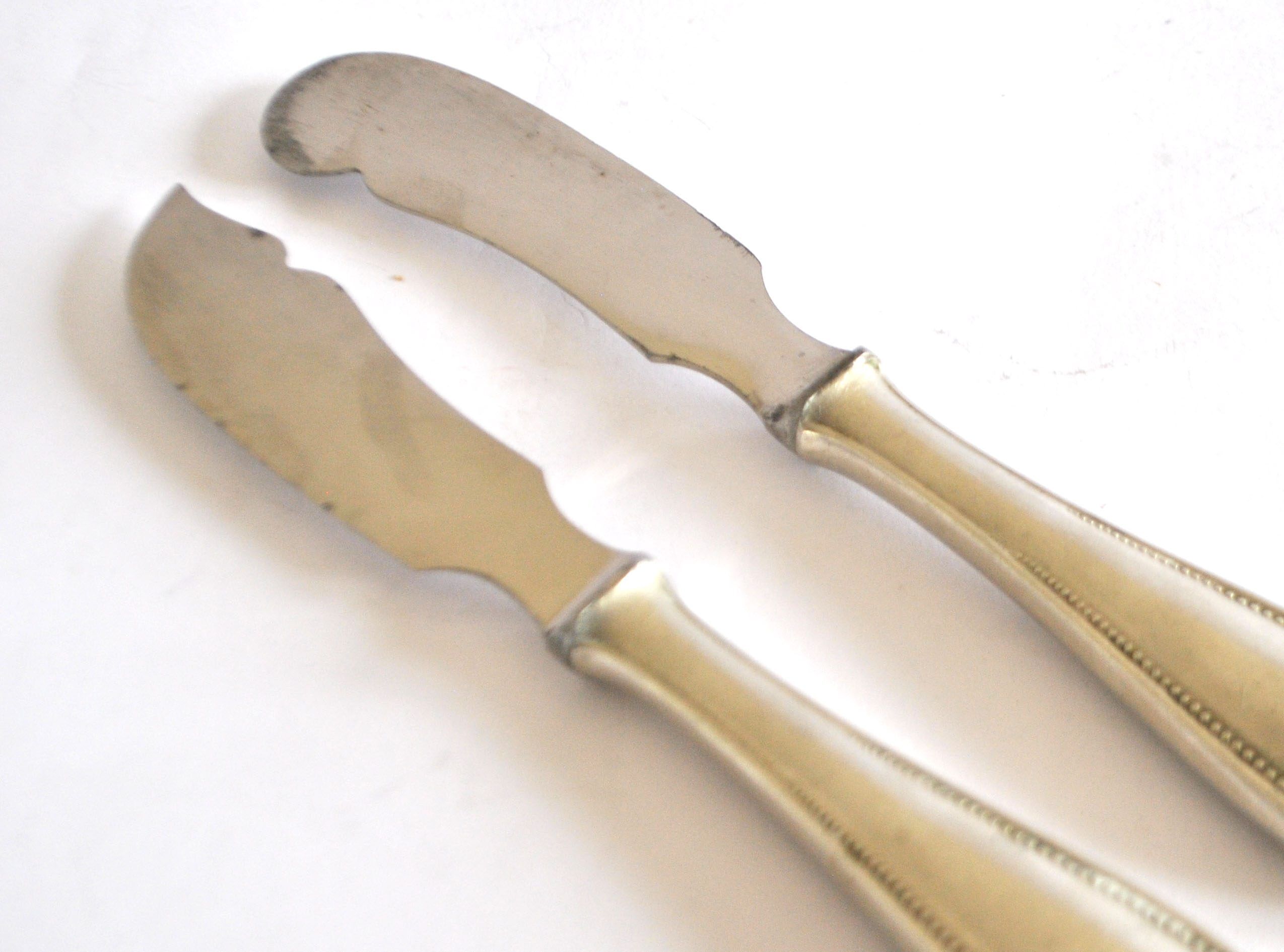 Two antique service knives in silver-plated metal, pearl frieze gowe alpacca.