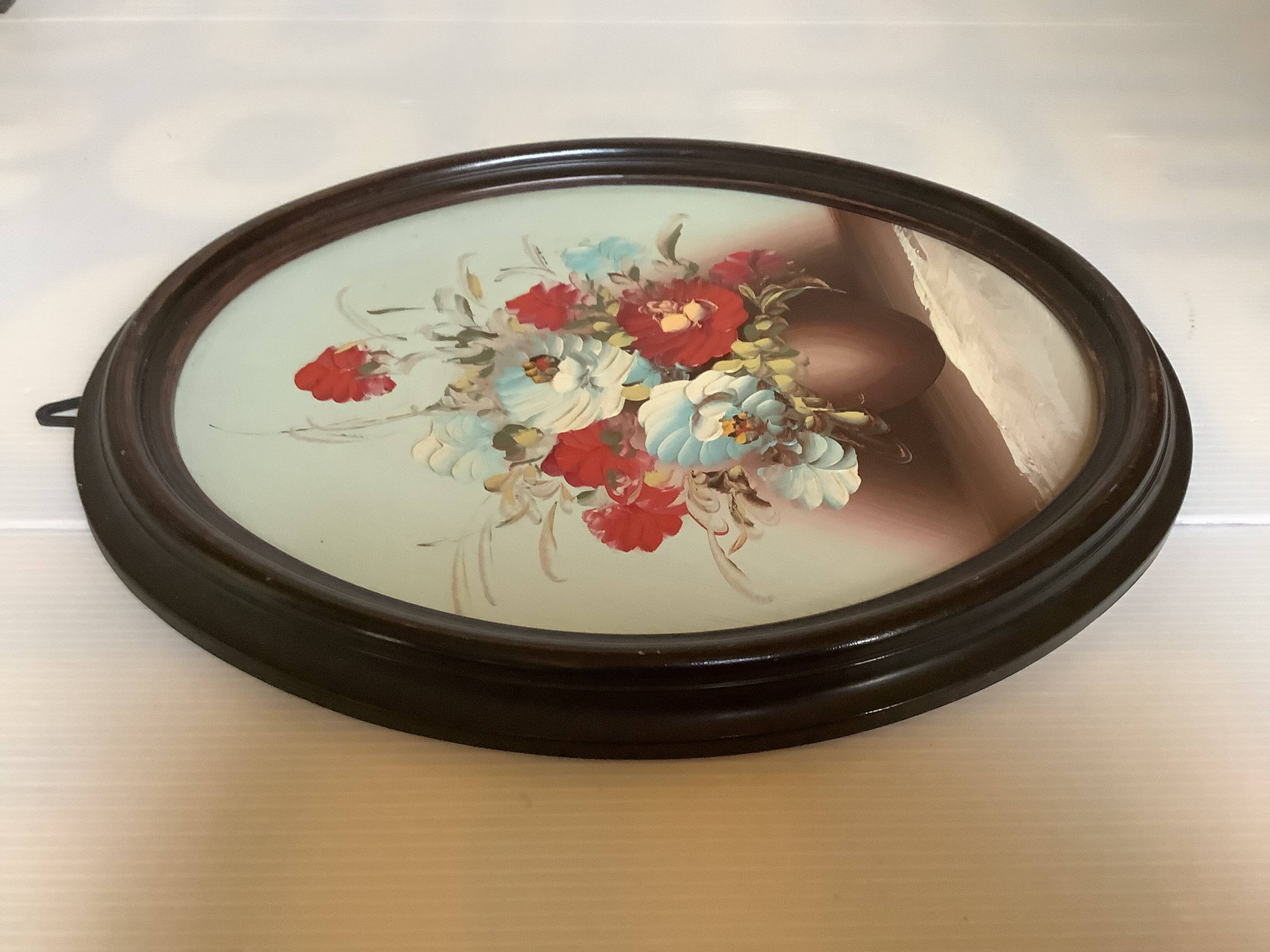 Oval painting of a bouquet of flowers, oil on panel.