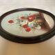 Oval painting of a bouquet of flowers, oil on panel.