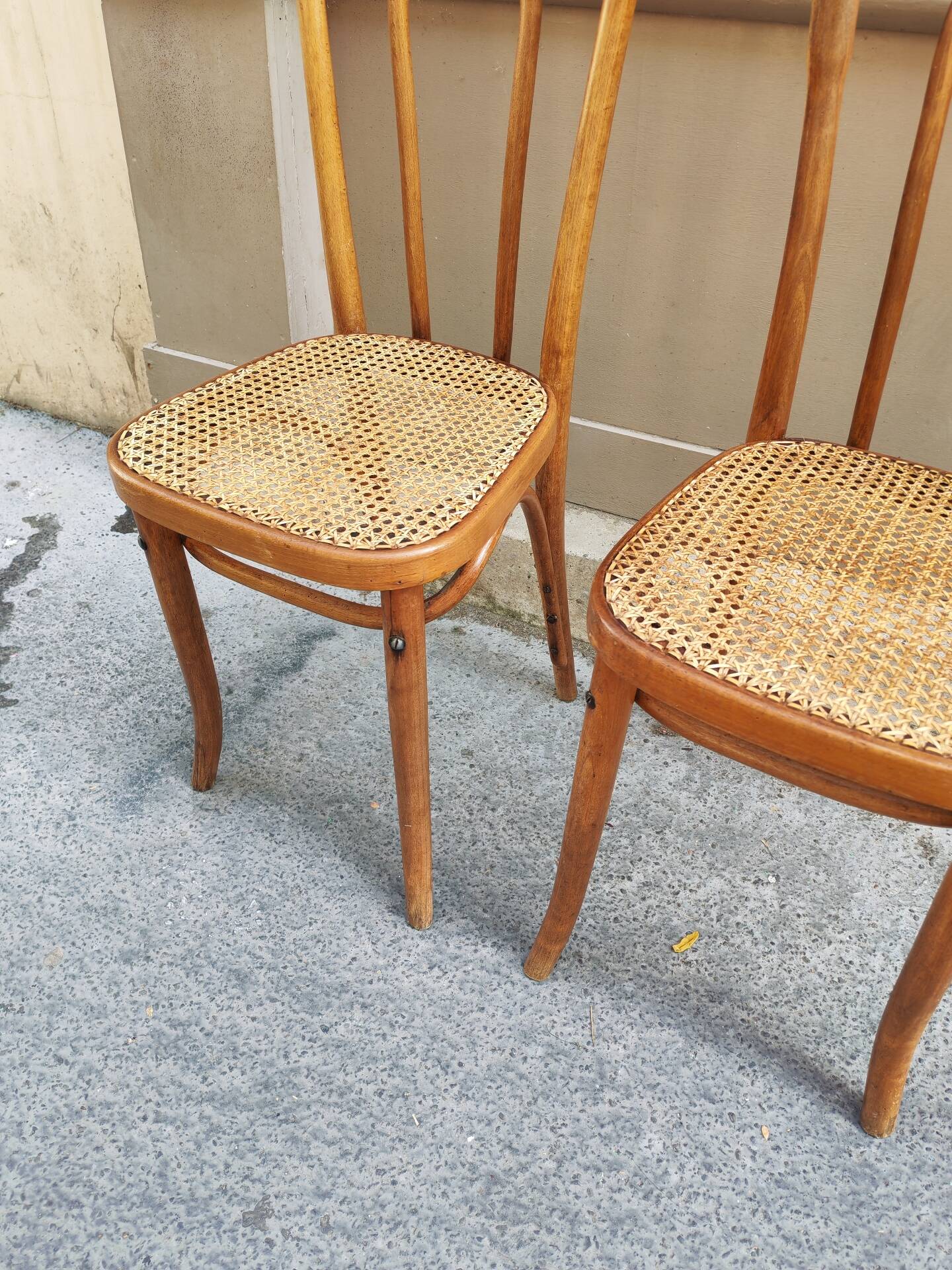 Pair of vintage bistro chairs in curved wood and caning.