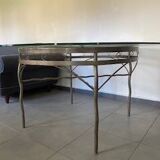 Round table with glass top and ornate metal base