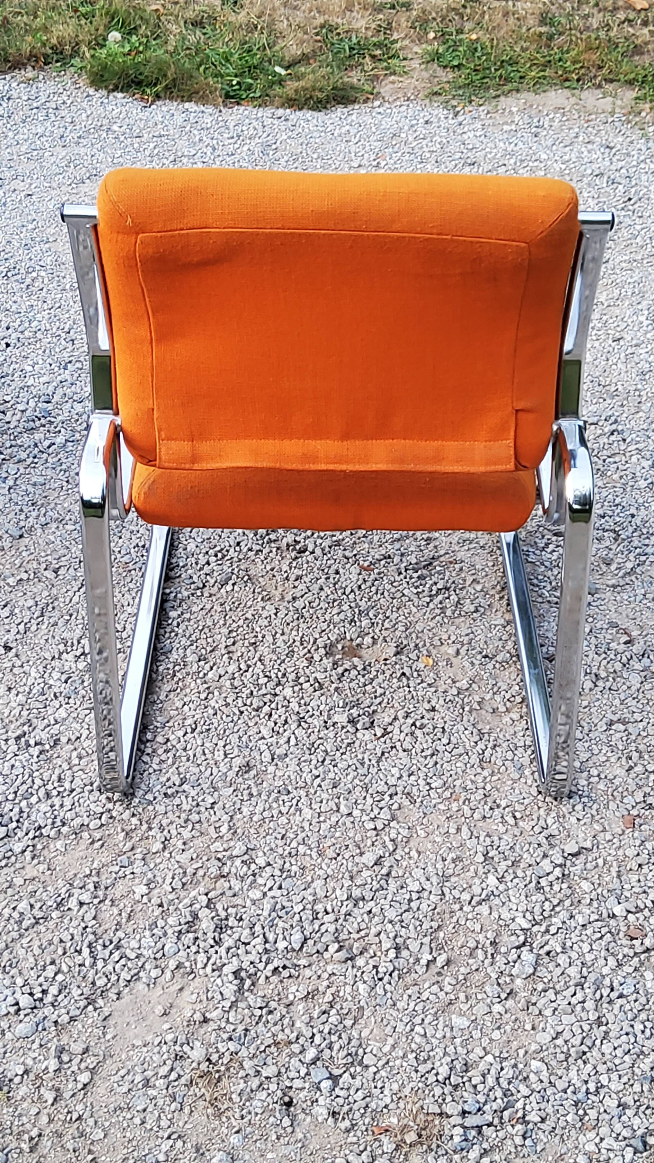 Pair of designer armchairs in orange fabrics and chrome tubes from the 70s