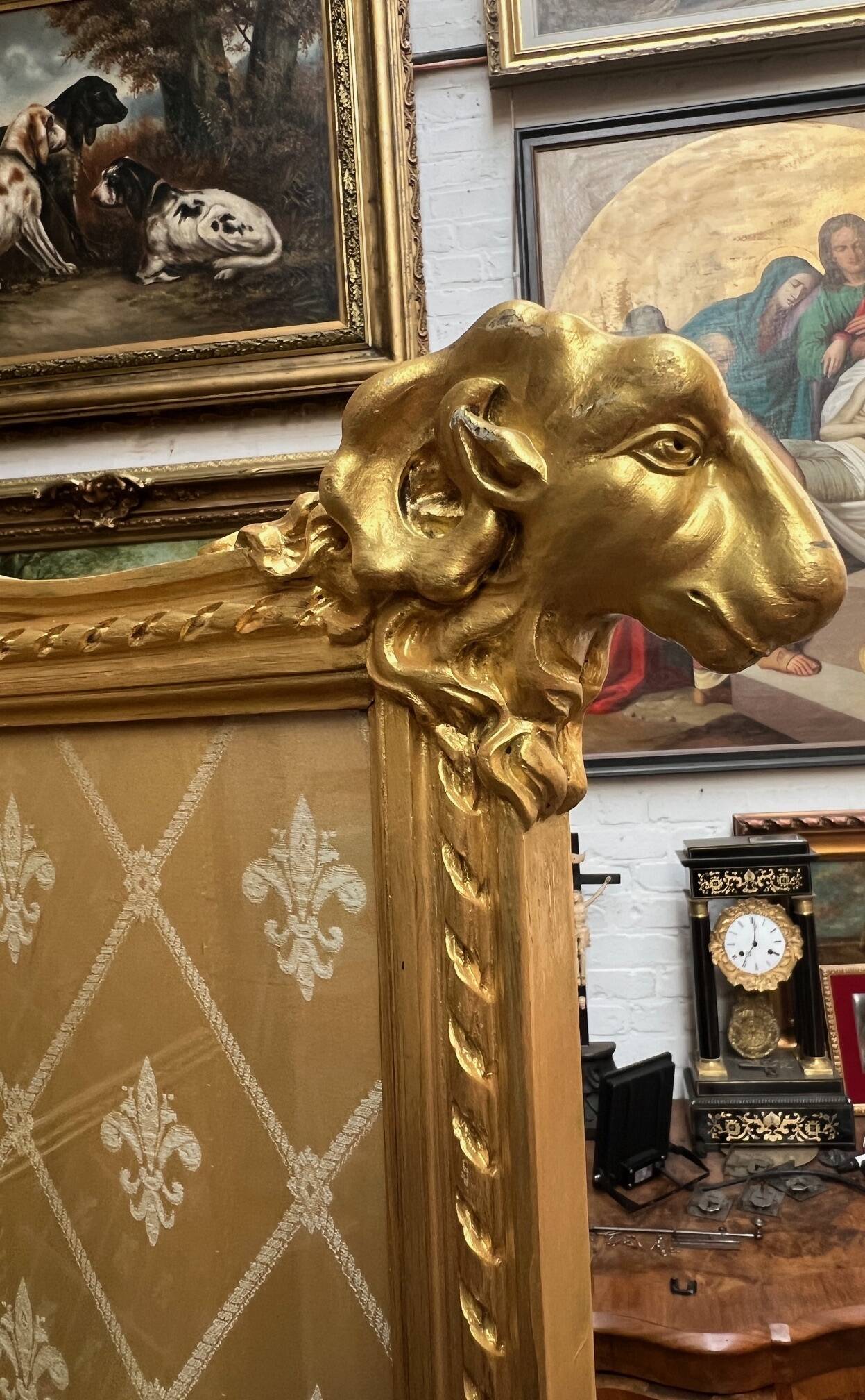 Paravent en bois doré décoré dans le style Louis XVI, orné de têtes de bélier.