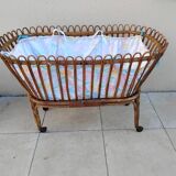 Vintage rattan bed on wheels cradle