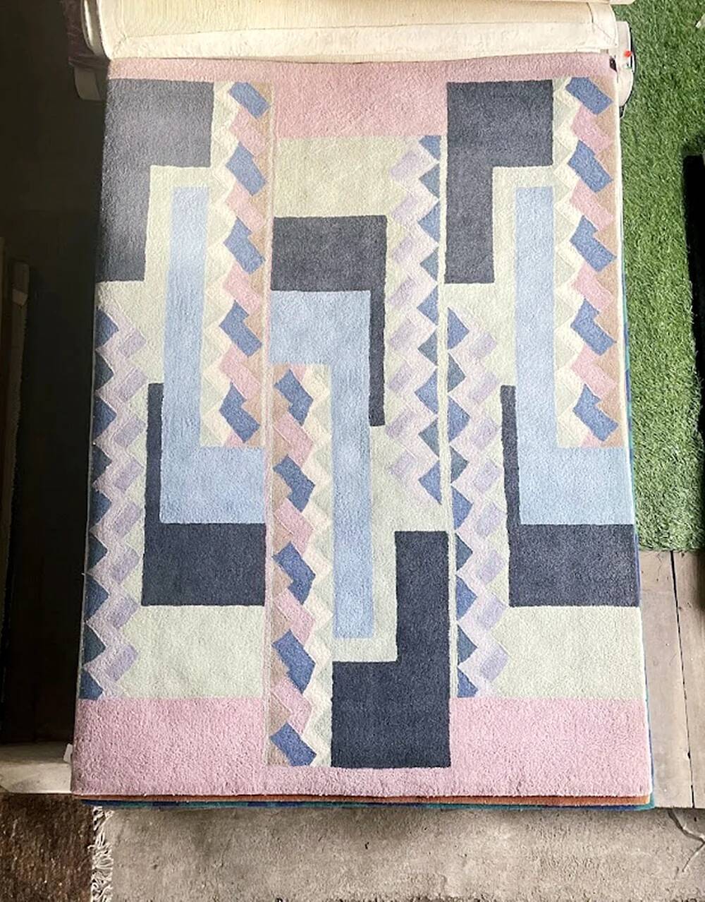 Hand-knotted wool rug by Tisca with a geometric pattern, signed "ILES", France, 1990s.