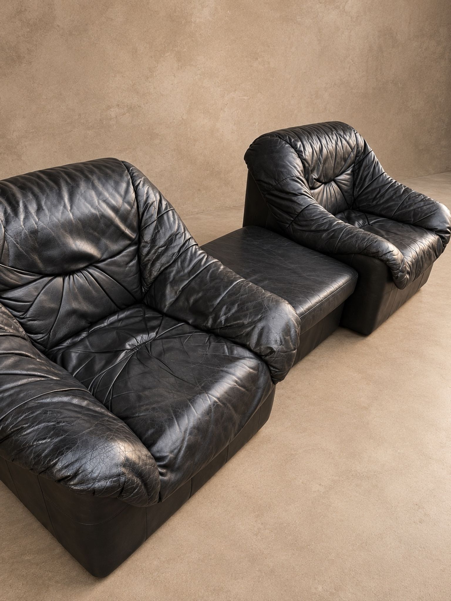 Leather armchairs and matching pouf, Italy, circa 1980