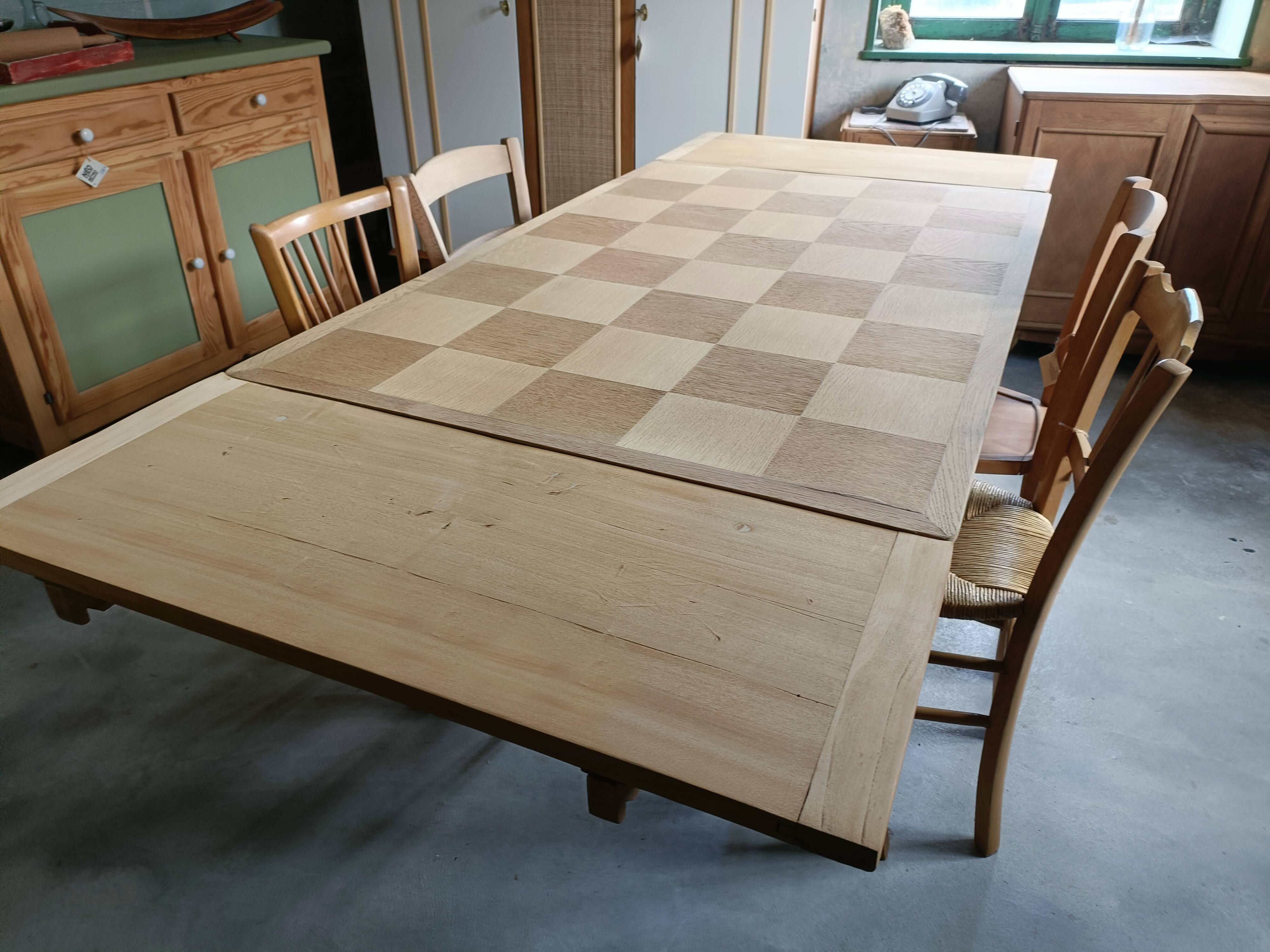 Oak dining table with a checkerboard top and extensions.