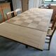 Oak dining table with a checkerboard top and extensions.
