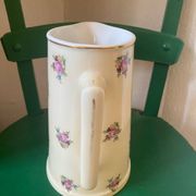 Old flowery and gilded pitcher.