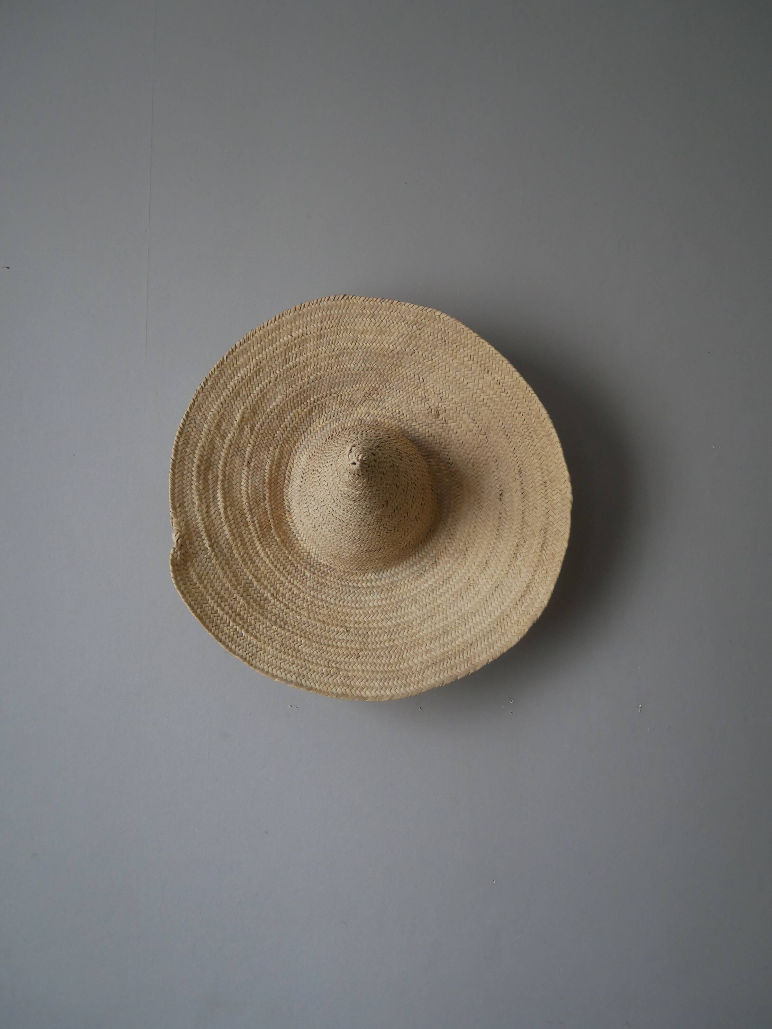Hand-woven wicker straw hat, artisanal production, decorative object, bohemian ethnic countryside