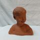 Terracotta bust of a smiling little boy.