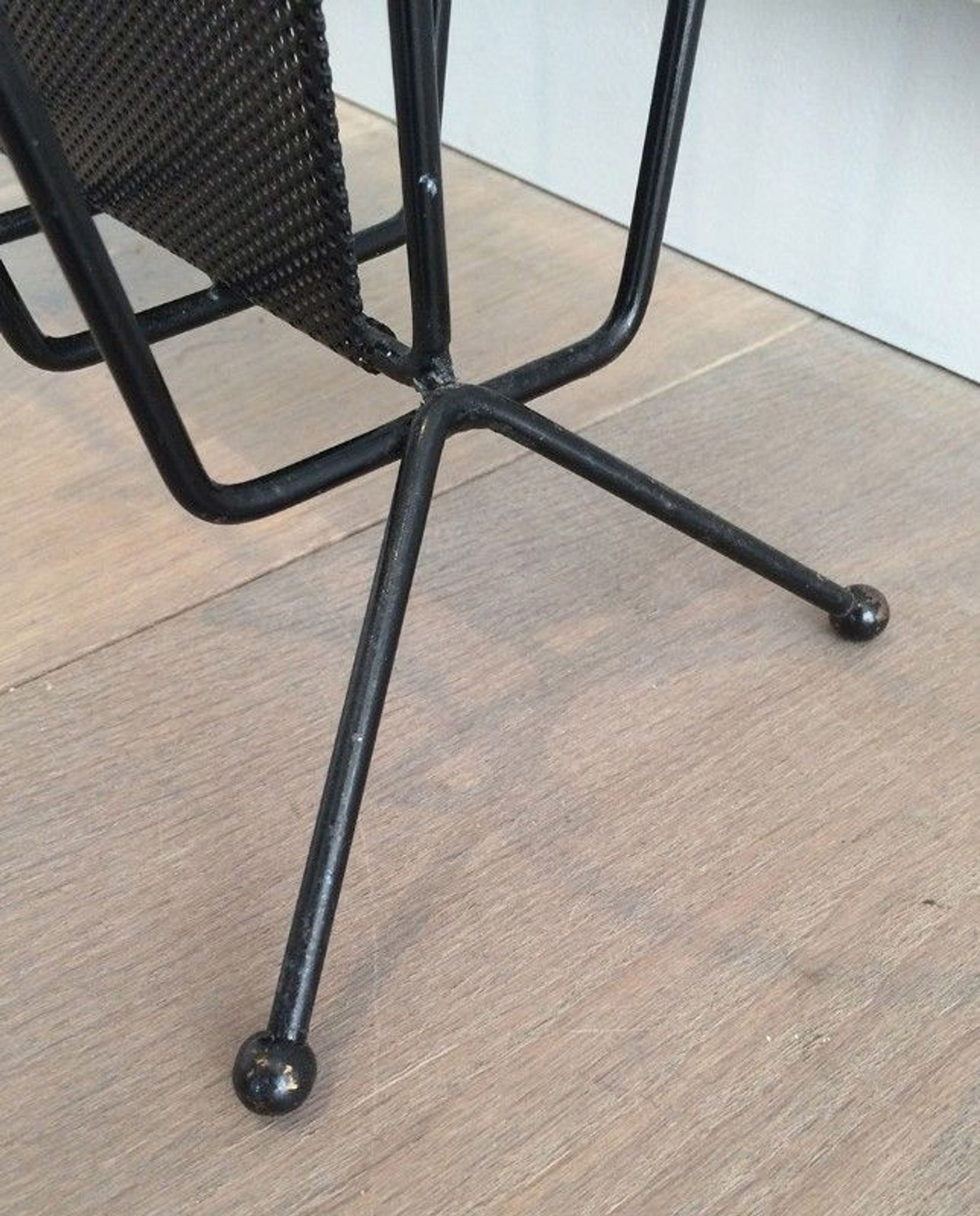 Black lacquered metal and perforated metal magazine rack designed by Mathieu Matégot 50.