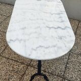 White and black oval marble table, wrought iron base