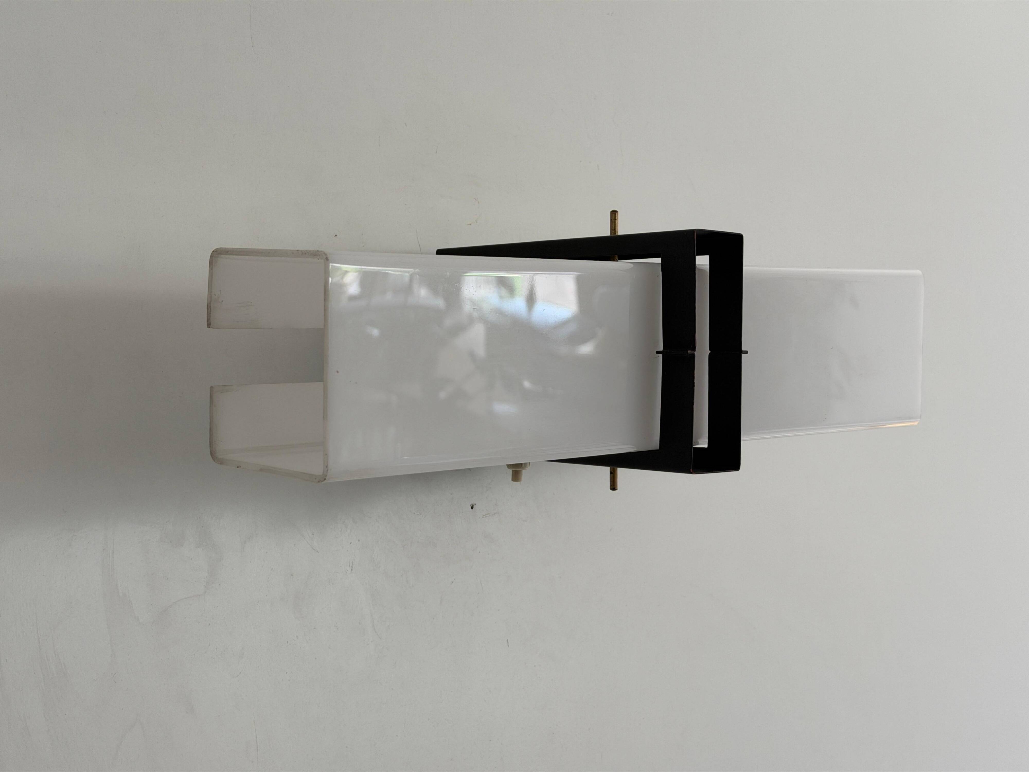 Simple white plexiglass wall light with a black metal frame, 1970s, Germany.