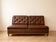 Vintage 1970s clic-clac sofa bed in brown faux leather.