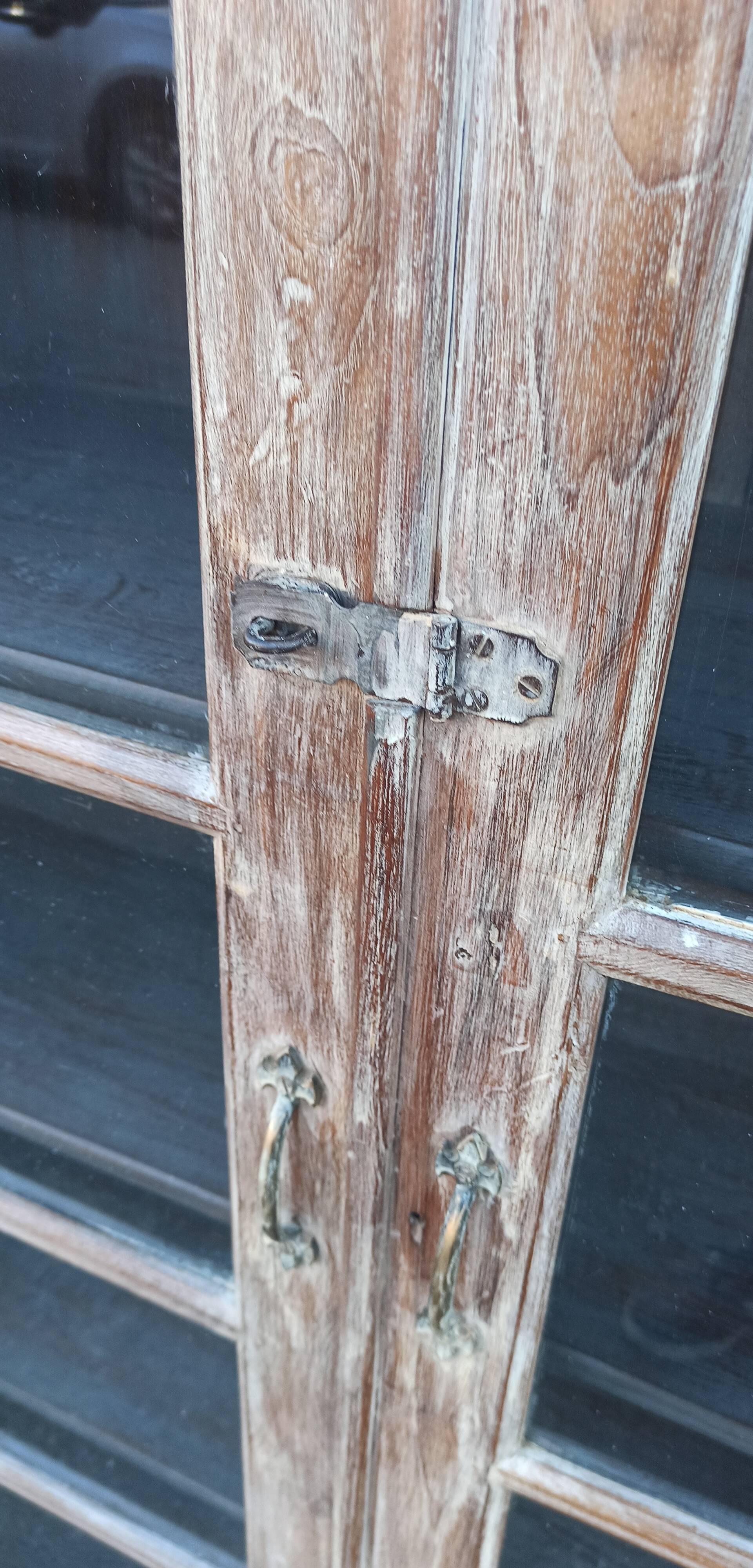 Glass cabinet in old whitewashed wood