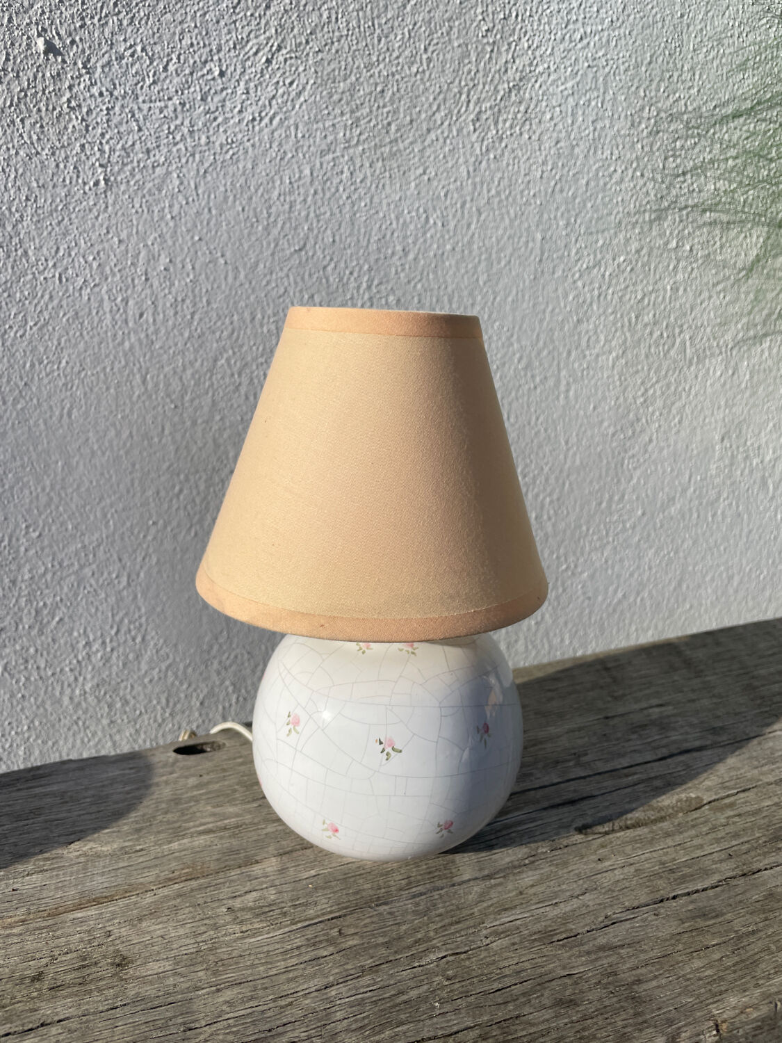 Small cracked white ceramic lamp with flowers.