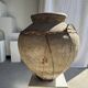 Very large grey and red terracotta pot with handles and rattan crossbars.