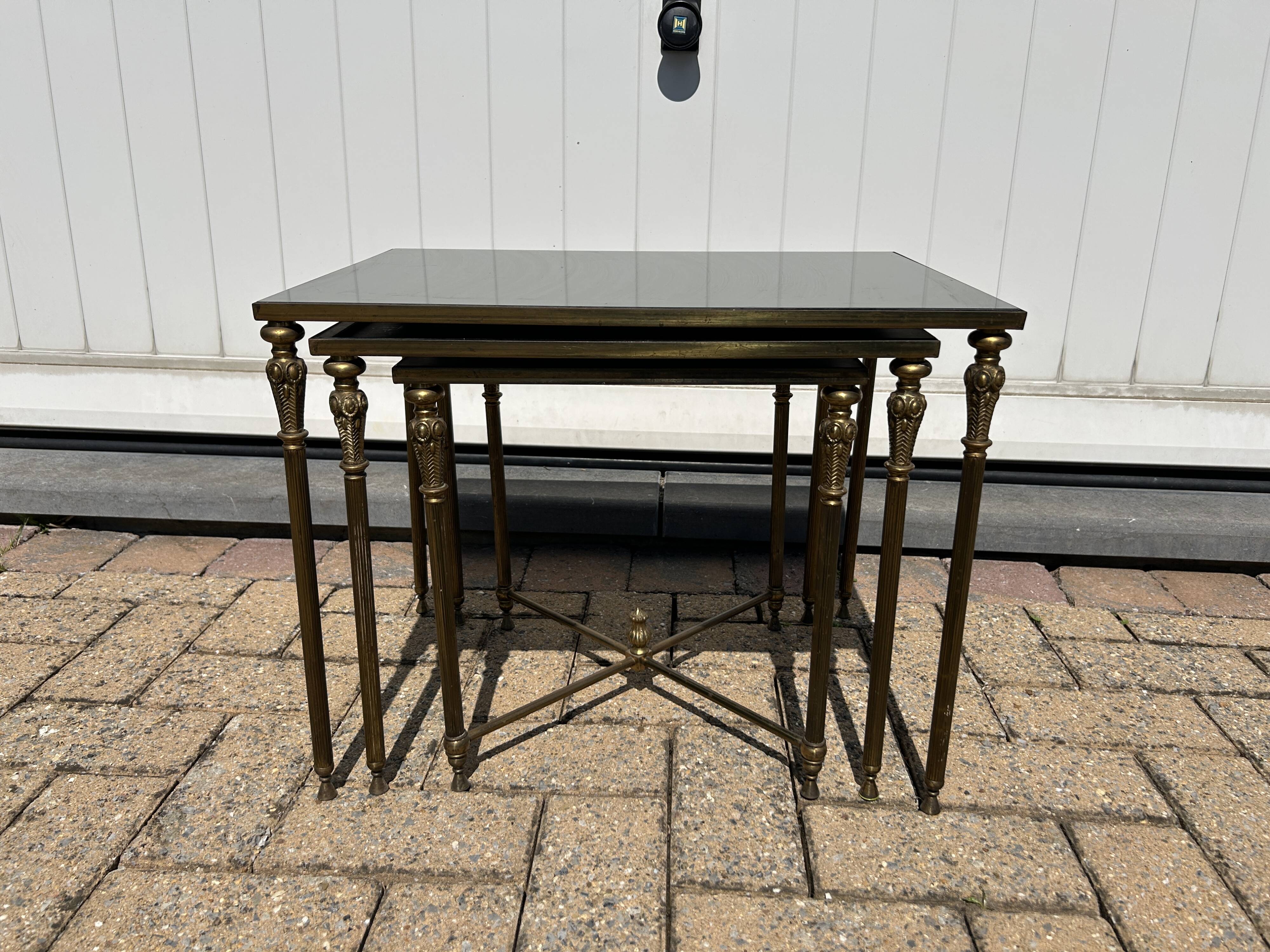 Nested tables in gilded brass in the style of Maison Charles.
