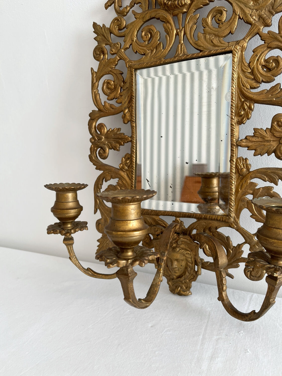 Bevelled mirror wall sconce in gilded bronze with 3 candle holders.