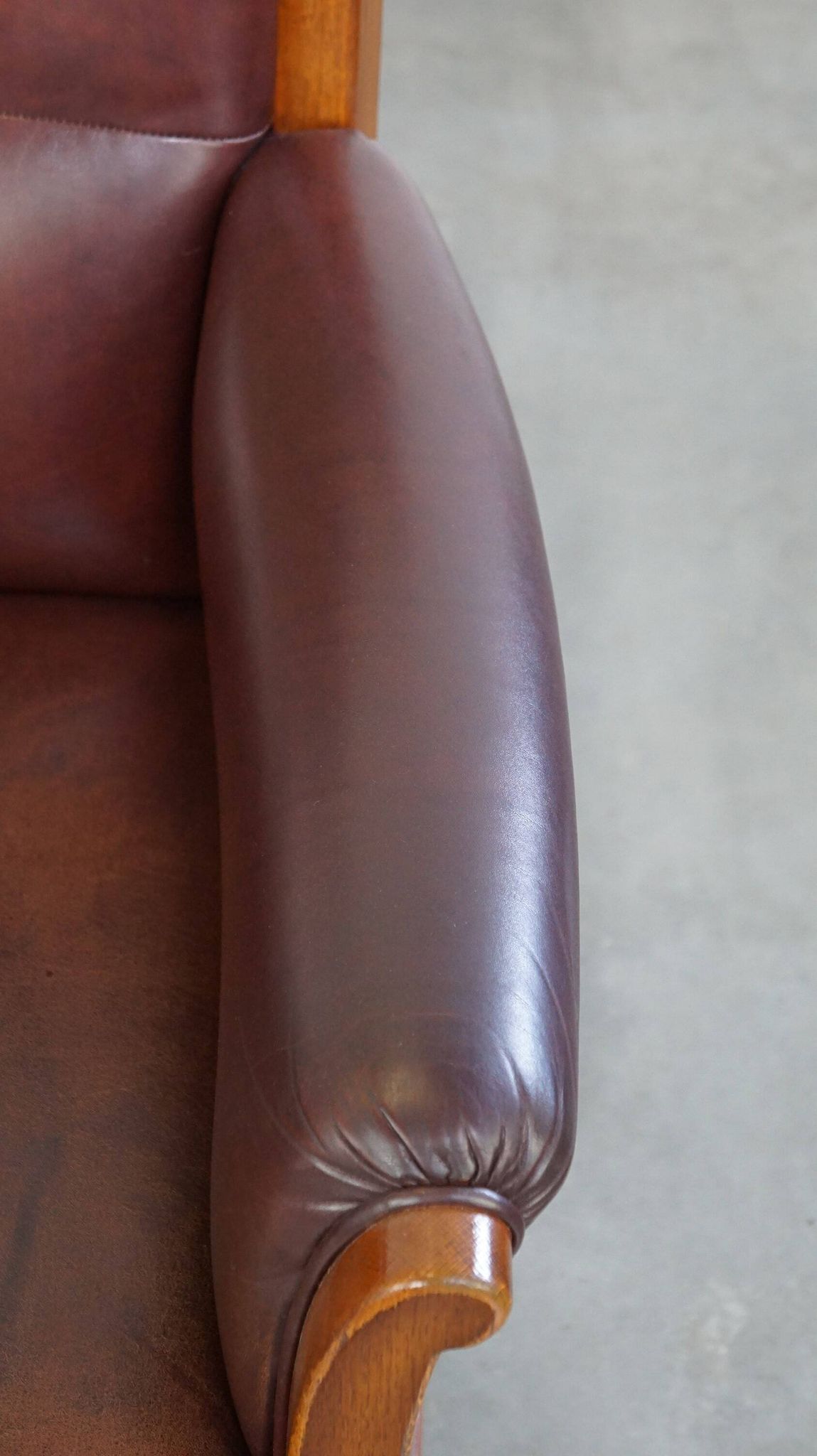 Very comfortable classic cowhide armchair with a high back in a mild Art Deco style