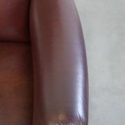Very comfortable classic cowhide armchair with a high back in a mild Art Deco style