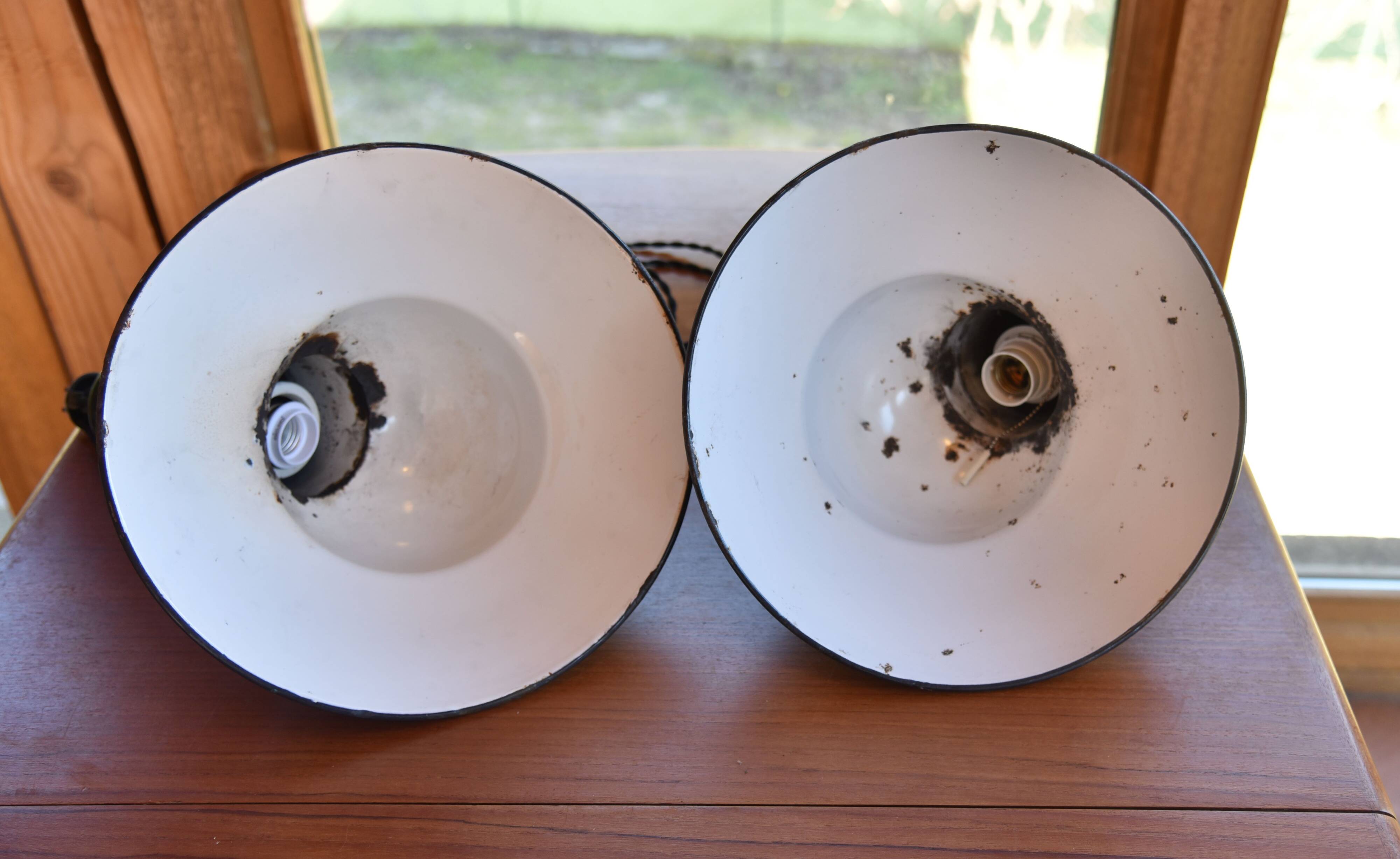 Pair of black enamelled sheet metal pendant lights from the 1950s.