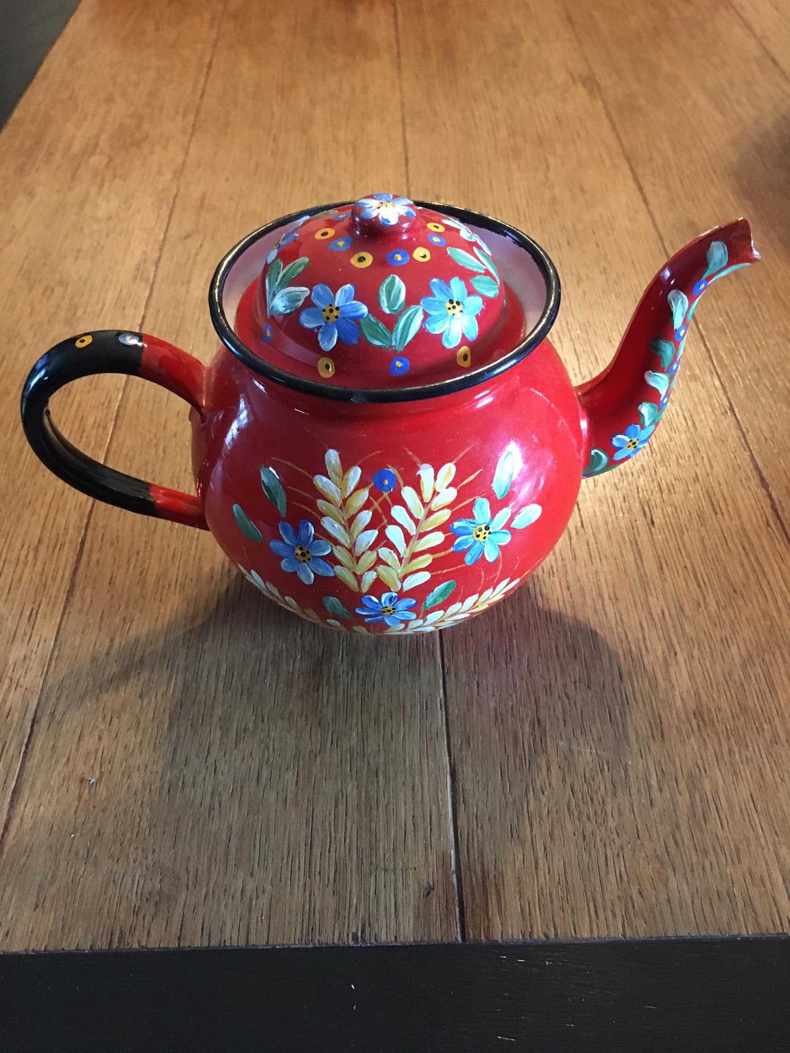 Red enamel teapot with hand-painted floral decoration