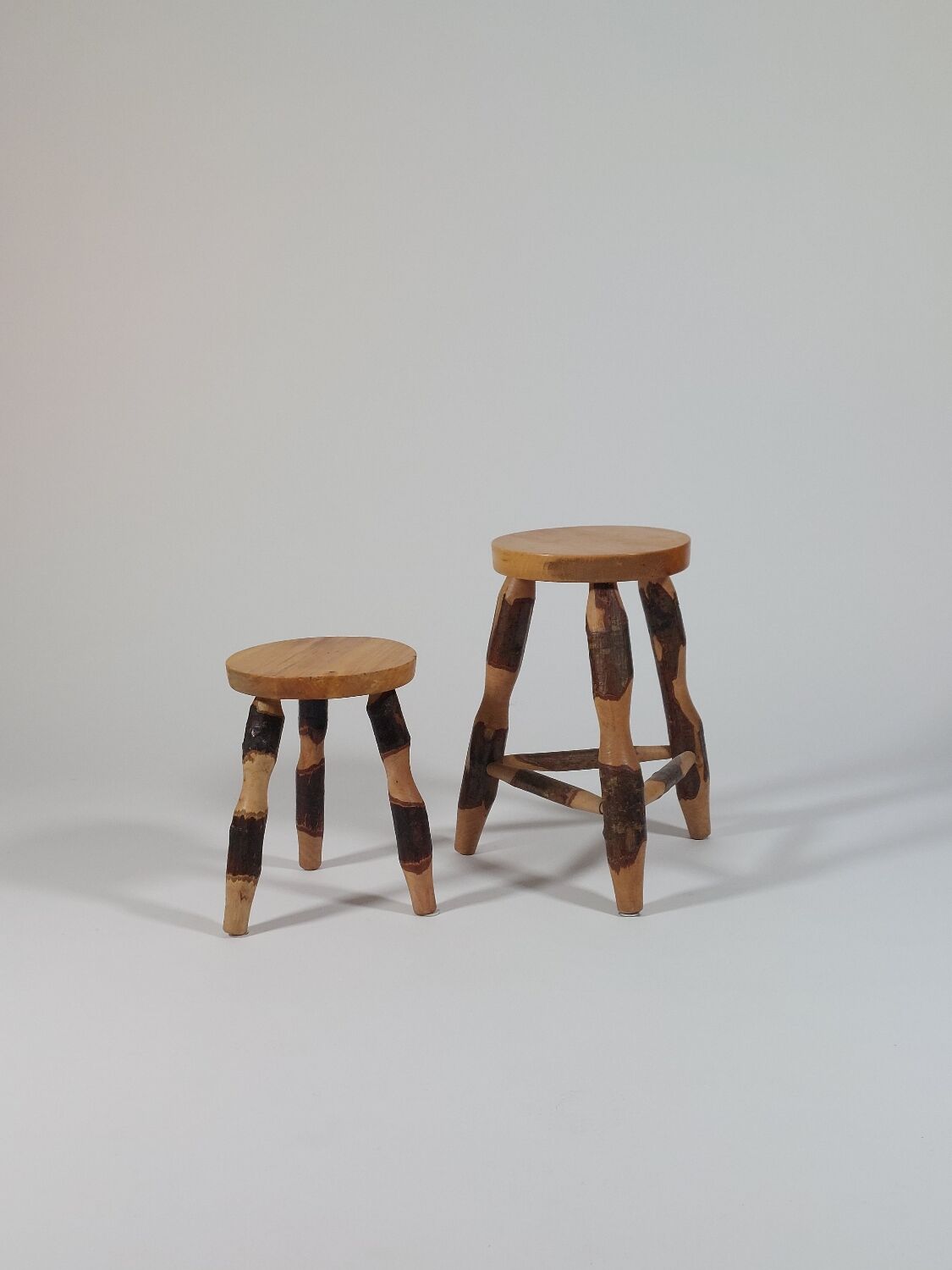 Pair of walnut stools sculpted in a vintage mid-century cross-section.