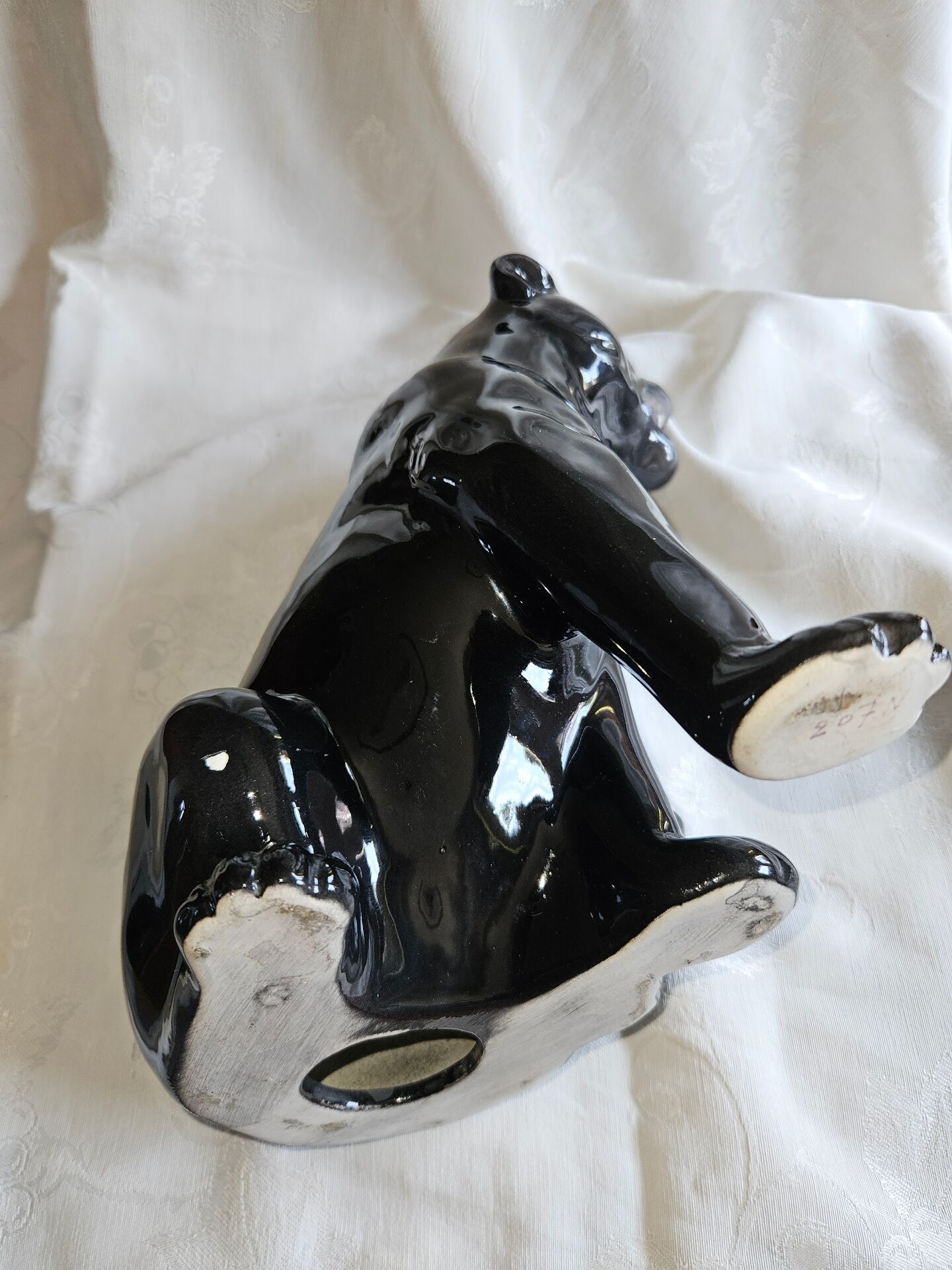Statue of a roaring panther/leopard sitting in black glazed ceramic.