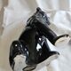 Statue of a roaring panther/leopard sitting in black glazed ceramic.