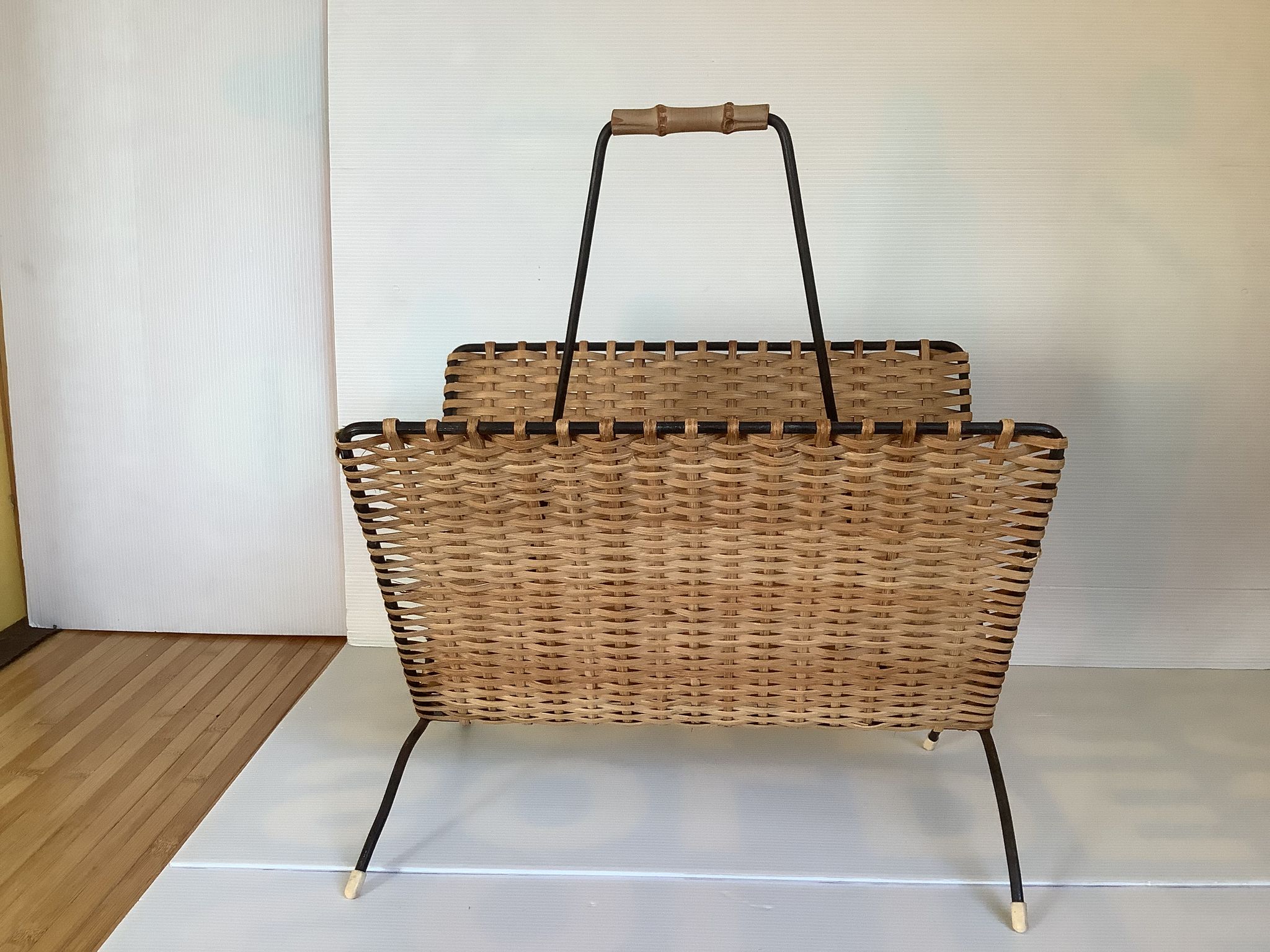 Old magazine rack in straw and black metal