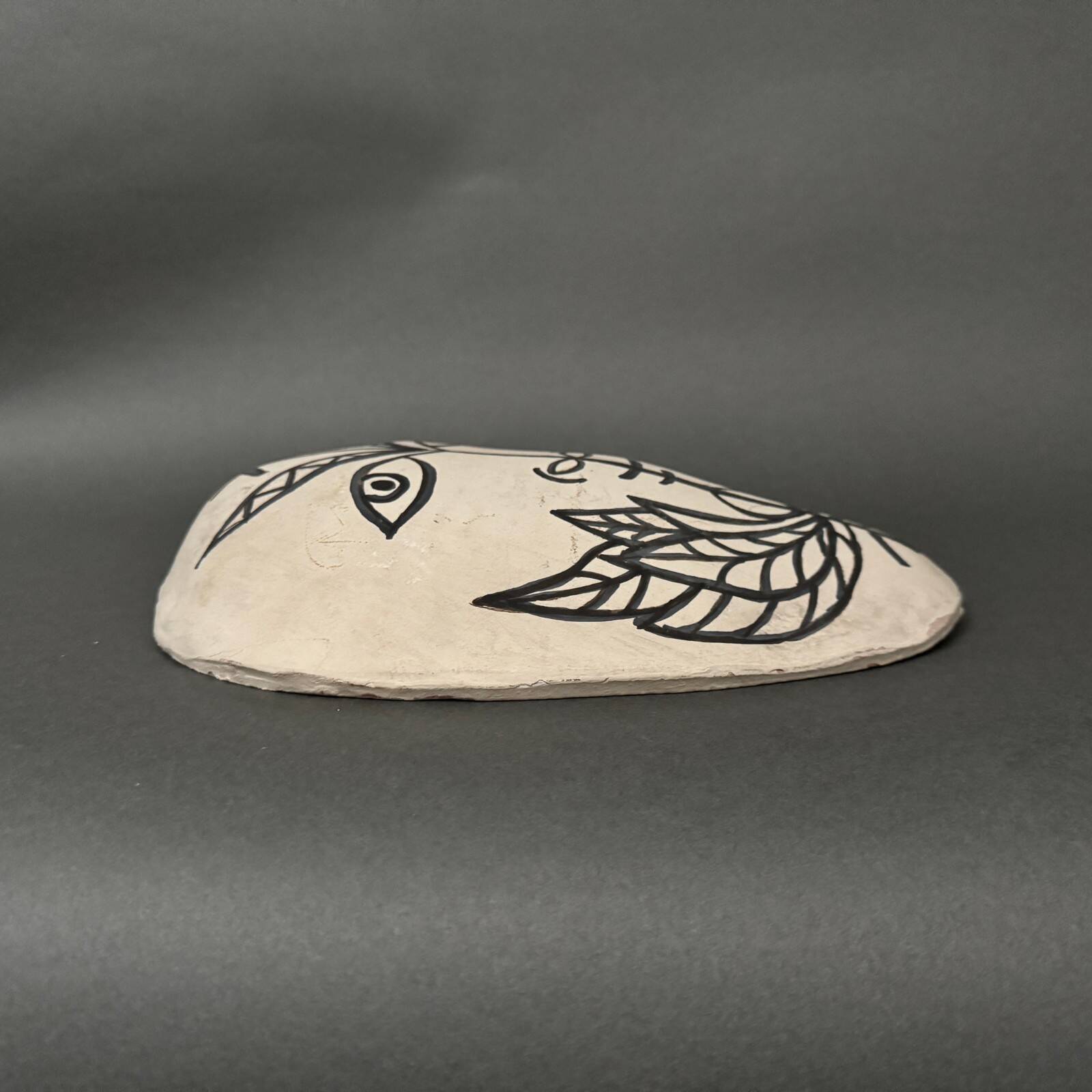 Africanist mask in glazed white terracotta, face signed Colette.