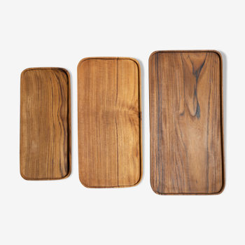 Trio of rounded rectangular trays or cups in monoxyl teak L:35