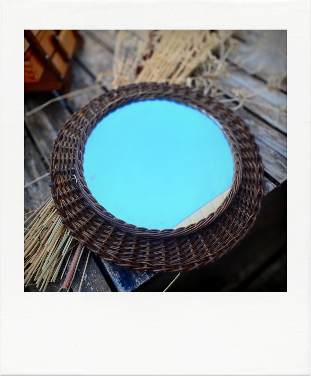 Round mirror in dark rattan