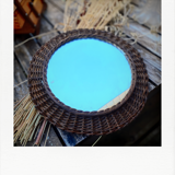 Round mirror in dark rattan