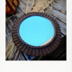 Round mirror in dark rattan