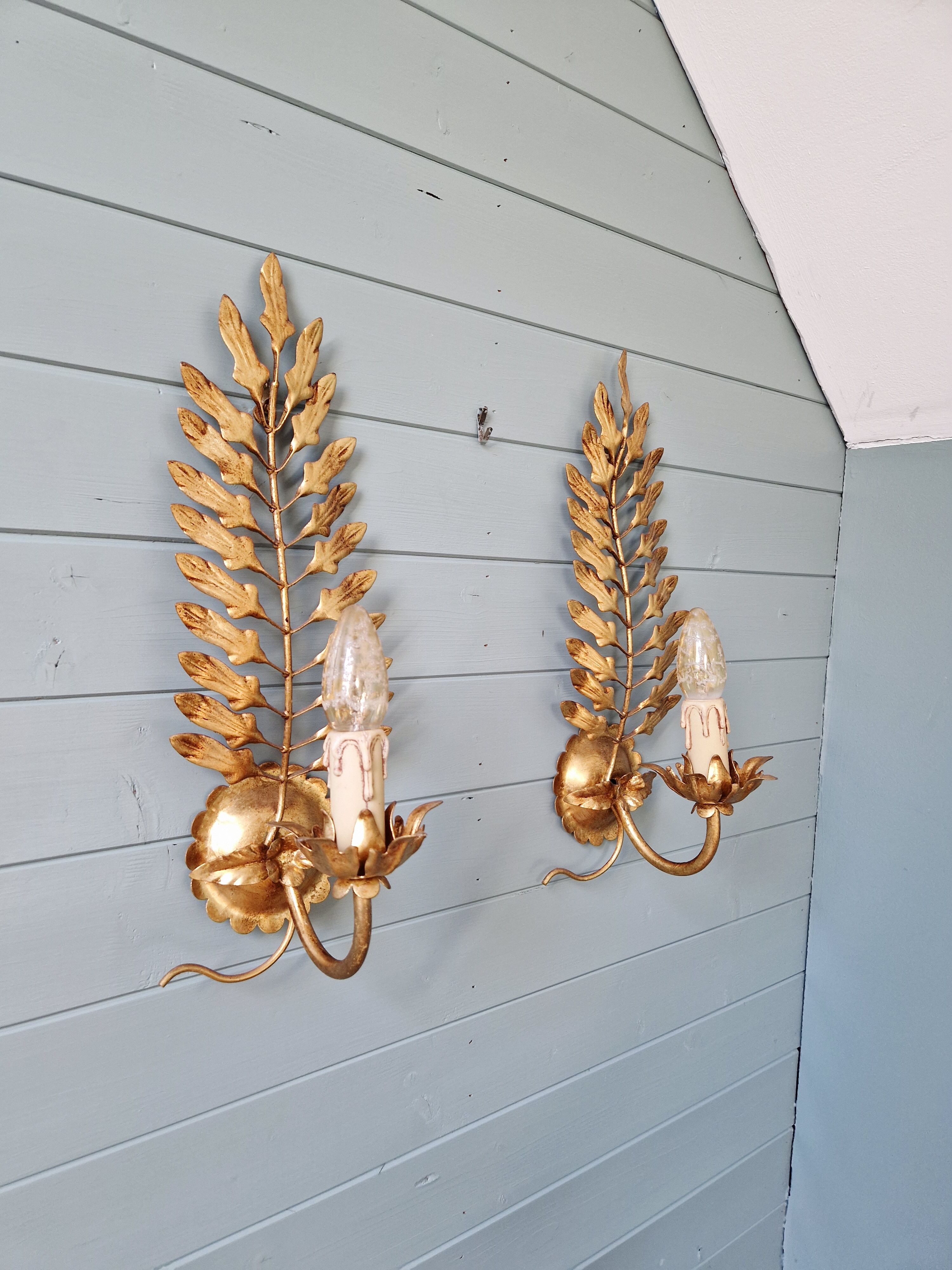 Pair of gold metal wall sconces in Hollywood Regency style, 1970s.