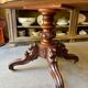 Table with a carved wooden frame and grey marble top on wheels, measuring 130 x 82 cm.