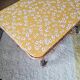 Table basse en rotin plateau tissu fleuri jaune