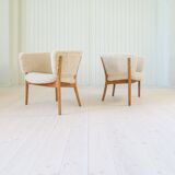 Mid-century lounge chairs in sheepskin/shearling and stained wood, Sweden, 1962.