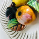 Covered basket in white woven ceramic and fruit slip.