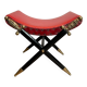 Neoclassical curule stool in red leather, decorated with crossed swords in bronze and metal covered in black leather.