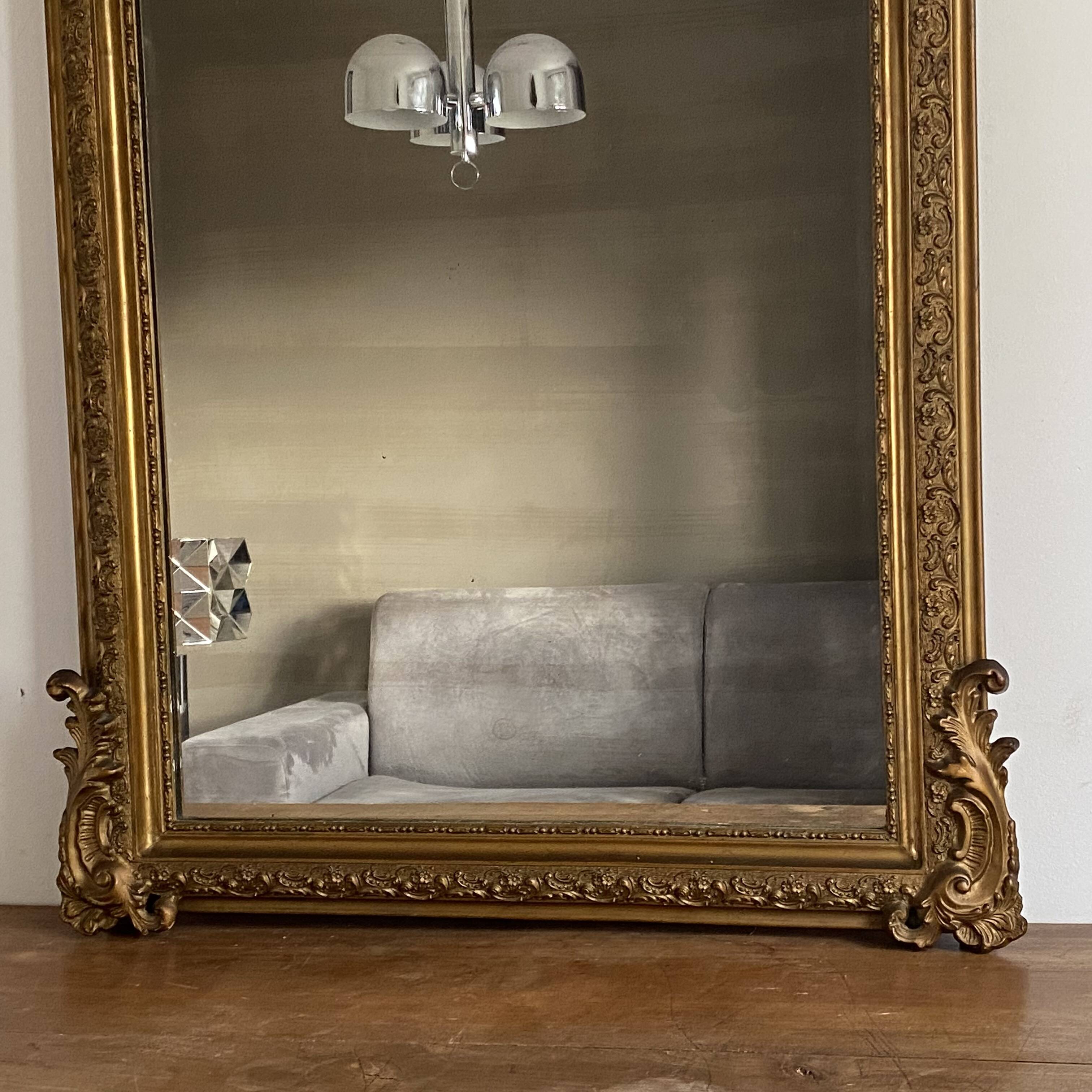 Late 19th century gilded mirror with decorated pediment. 155x88.