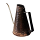 Old watering can in red copper and brass