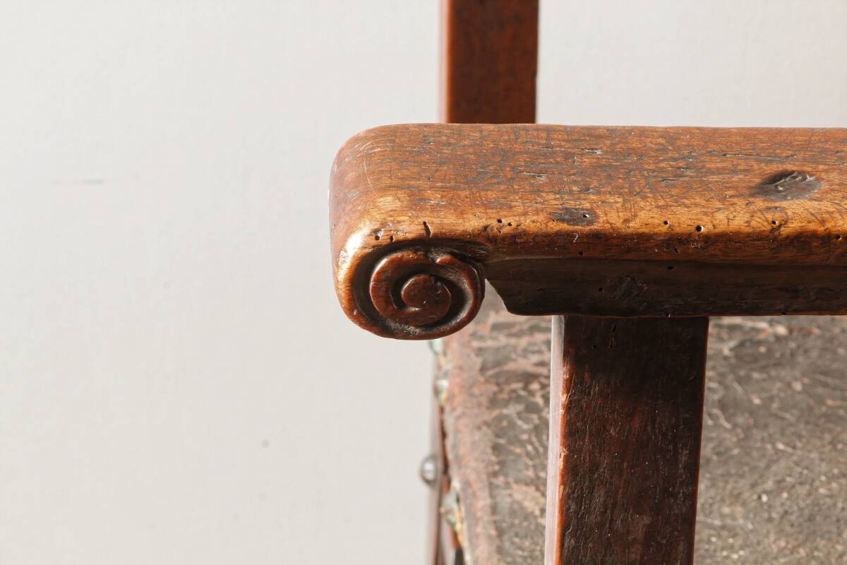 Antique armchair in walnut and studded leather, 17th century