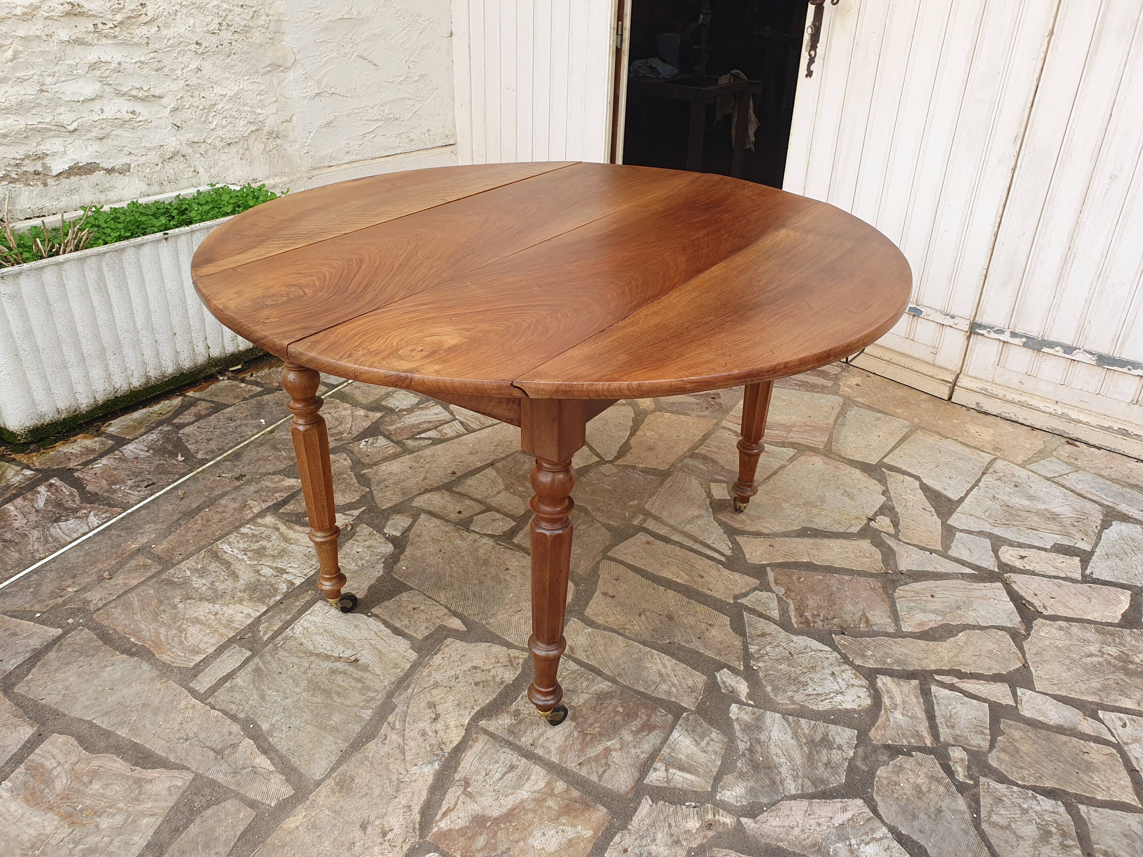 Round extending table in solid walnut, 19th century