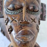 A large Senufo mask made of colored wood, decorated with an anthropomorphic figure